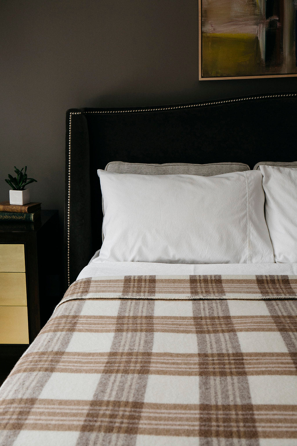 Luxurious bed with Evangeline linens, plaid merino wool blanket, and plush pillows in king, queen, and twin sizes.