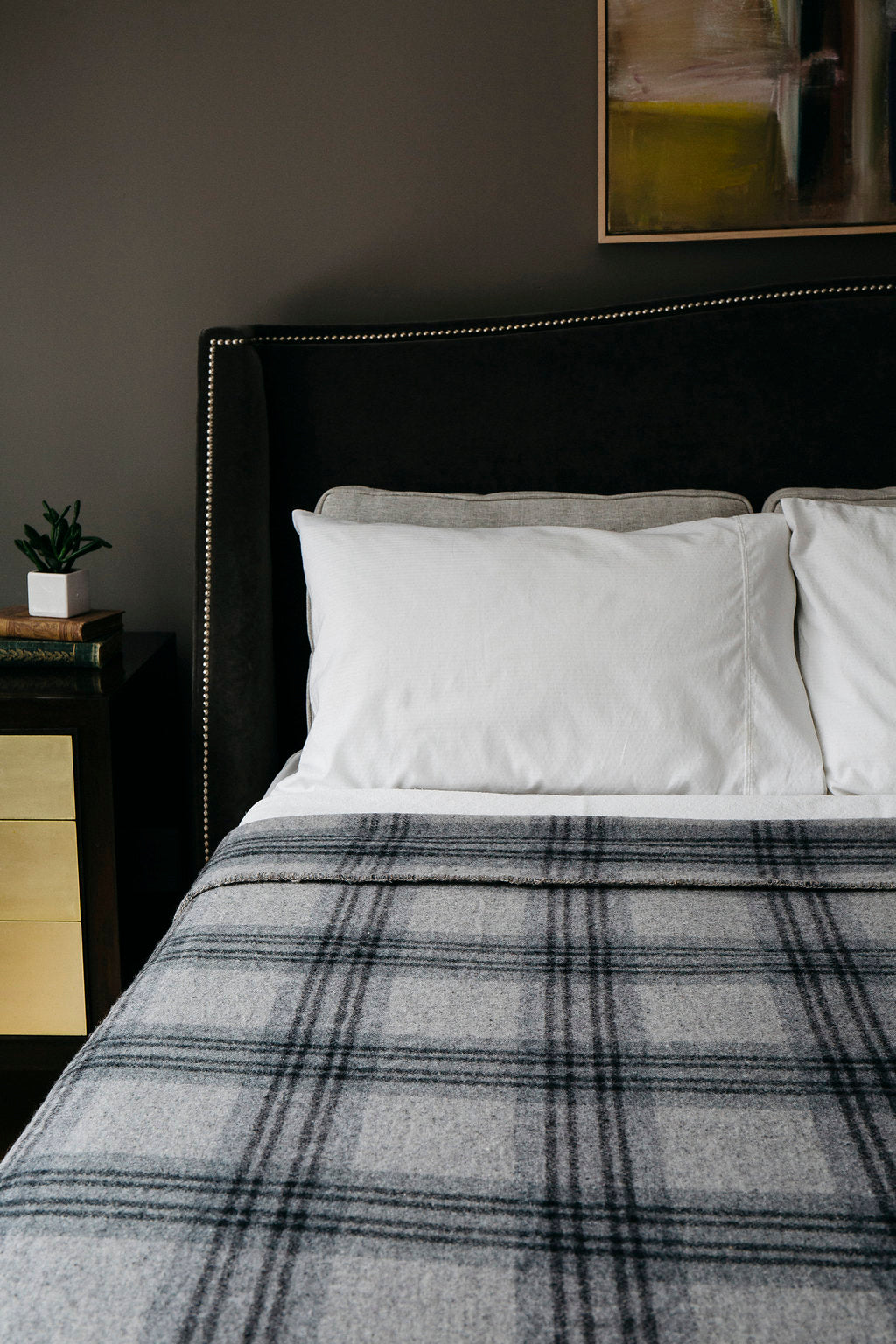 Luxurious bed with Evangeline linens, plaid merino wool blanket, and plush pillows in king, queen, and twin sizes.