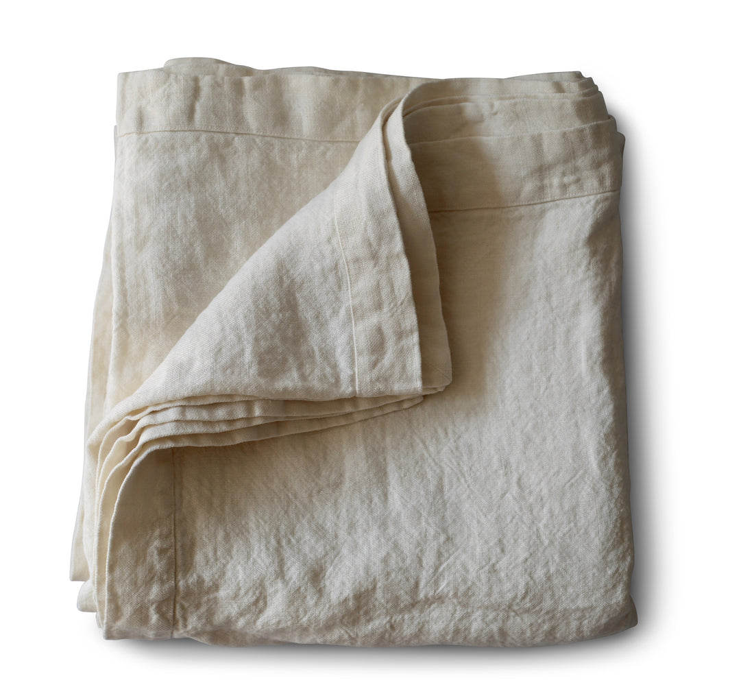 Evangeline Bright White four seasons linen. Folded agaisnt a white background. 100% linen A substantial weight. Two classic colorways available in Full/Queen and King sizes.