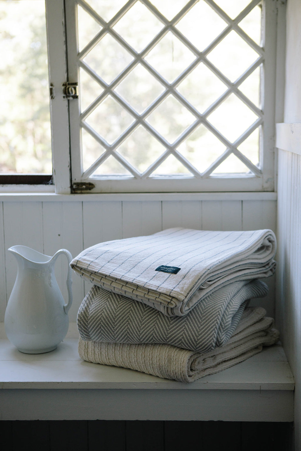 Stack of folded Cotton Evangeline Linens blankets. Best cotton bed blankets from Portland Maine. Beautiful heavy four season cotton blankets.